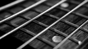 Image showing guitar strings in close up against a guitar fretboard on a page for guitar lessons